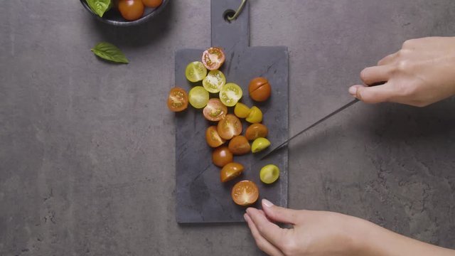 Hands Cutting tomatoes on a cutting board timelapse