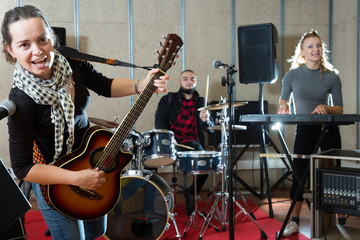 Young girl guitar player and singer with band