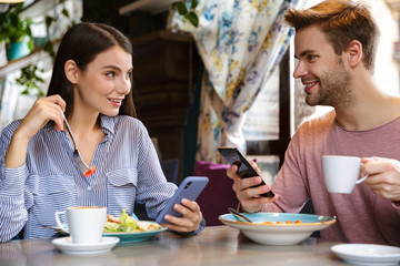 Attractive young couple having lunch at the cafe indoors