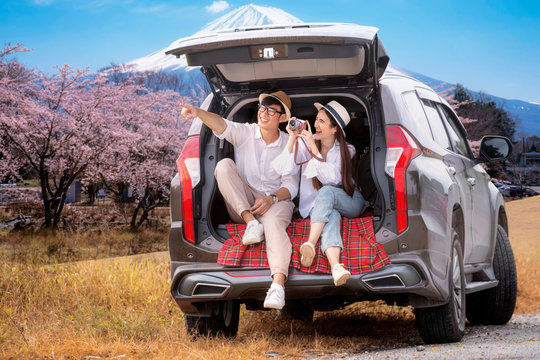 Asian couple travel Fuji mountain by suv car