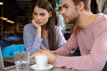 Attractive young couple having lunch at the cafe indoors