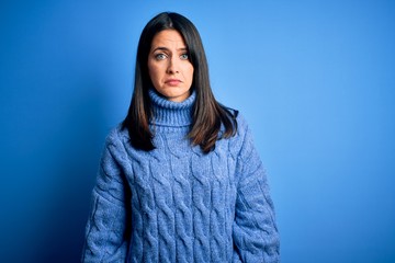 Young brunette woman with blue eyes wearing casual turtleneck sweater depressed and worry for distress, crying angry and afraid. Sad expression.