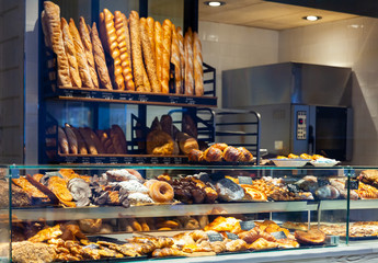 Bakery shop with assortment of bread on shelves - obrazy, fototapety, plakaty