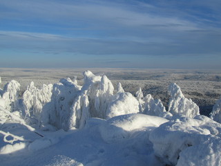Fototapeta na wymiar Endless winter taiga to the horizon and the sky with clouds. View from the top of the mountain.