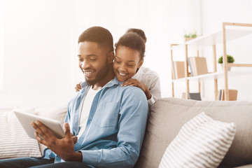 Positive african father and daughter using digital tablet