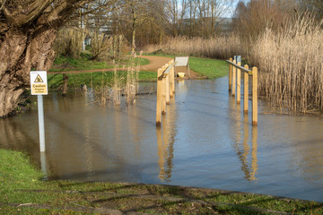 A walkway is submerged as a lake has flooded and submerged the pathway.