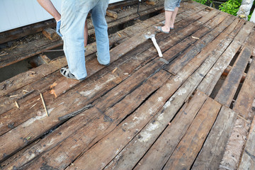 Replace and repair old house roof with bad rotten, wet wooden beams and wet rock wool insulation material. Roofing construction