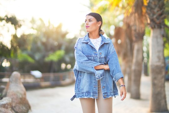 Young beautiful woman wearing denim jacket smiling happy and confident. Standing with smile on face at the town park