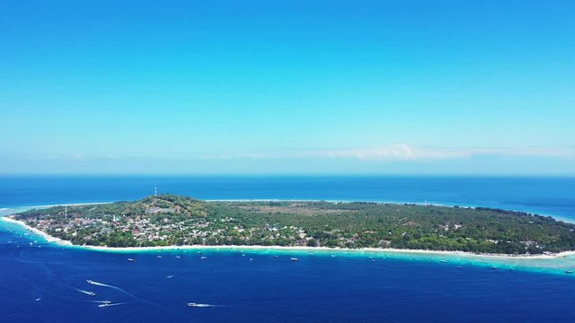 Paradise vacation destination, tropical island with lush vegetation surrounded by blue azure sea water under a bright clear sky, gili trawangan, Indonesia