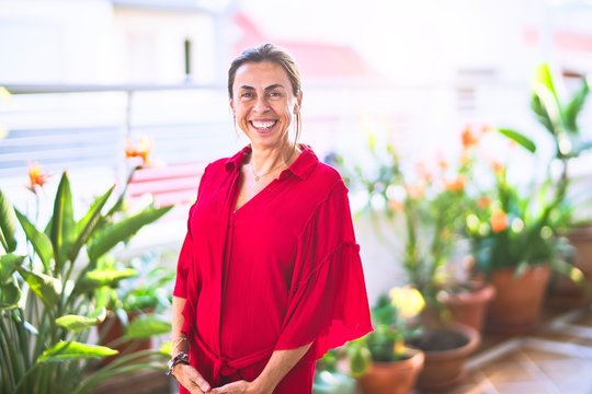 Middle age beautiful woman smiling happy and confident standing with a smile on face at terrace