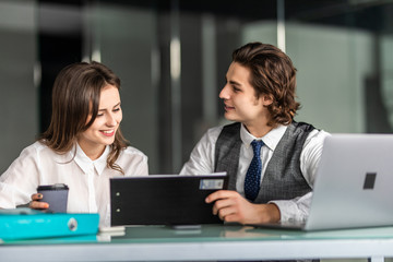 Business people man and woman working together with a laptop computer in office