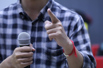 The person with the microphone while speaking in the meeting room