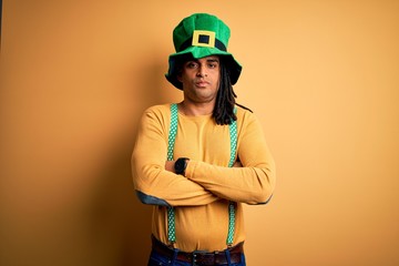 Young african american man wearing green hat celebrating saint patricks day skeptic and nervous, disapproving expression on face with crossed arms. Negative person.