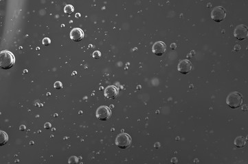 Dark background. Liquid with air bubbles for projects, oil, honey, beer, juice, shampoos. Black and white