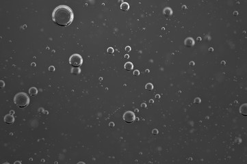 Dark background. Liquid with air bubbles for projects, oil, honey, beer, juice, shampoos. Black and white