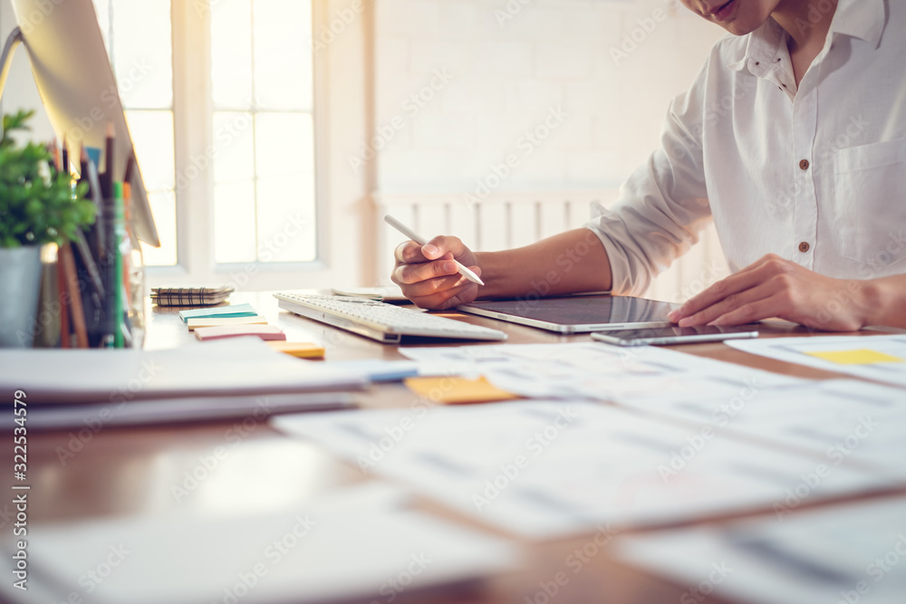 Wall mural designer man drawing a website outline and website ux app development on mobile phone.