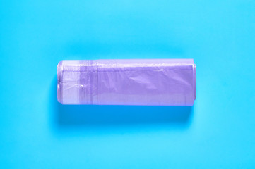 One purple disposable plastic garbage bag on blue background. Top view. Close-up