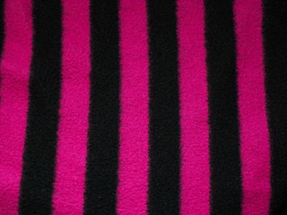 Striped background. Black and pink stripes. Textile wool fabric as an abstract background for design.
