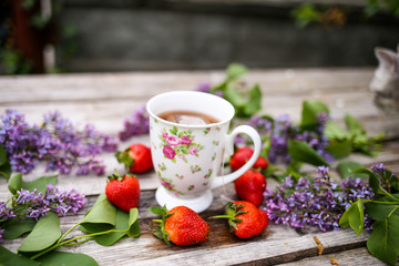 Cup of tea in the morning at home with flowers and strawberries