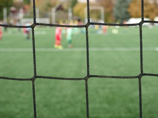Young soccer team on playground viewed through net
