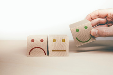 sad, neutral and happy smiling face symbol on wooden blocks, customer satisfaction and service...