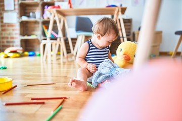 Fototapeta premium Adorable toddler playing around lots of toys at kindergarten