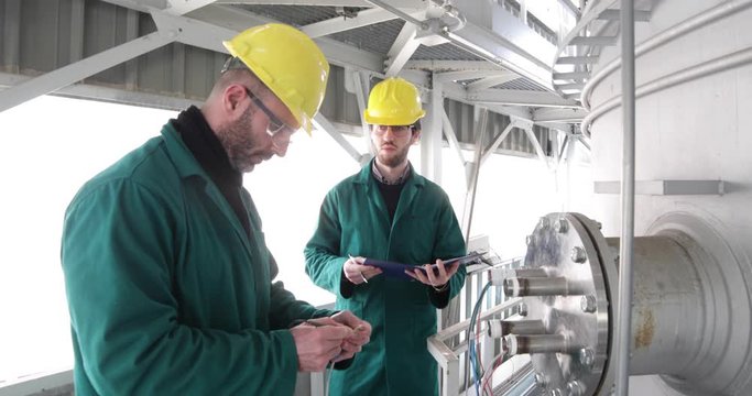Due tecnici stanno collaudando il nuovo serbatoio a pressione