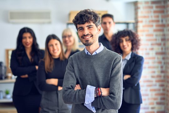 Group of business workers smiling happy and confident. Posing together with smile on face looking at the camera, young handsome man with crossed arms at the office
