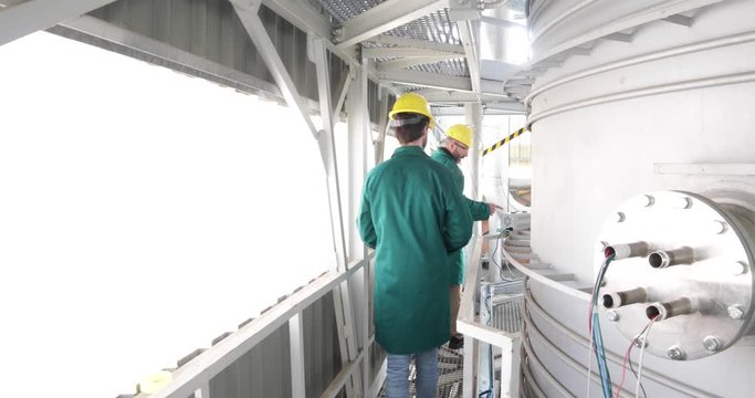 Due ingegneri energetici stanno controllando la cisterna in pressione di un apparato per l'energia