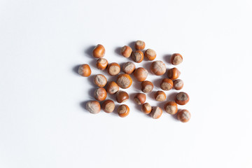 Top view on heap of ripe hazelnuts close up on white background