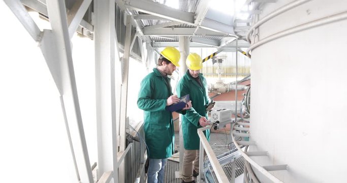 Due Ingegneri nucleari stanno sistemando una cisterna in pressione per il raffreddamento del nocciolo