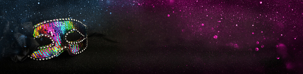 Photo of elegant and delicate colorful sequins Venetian mask over dark glitter background © tomertu