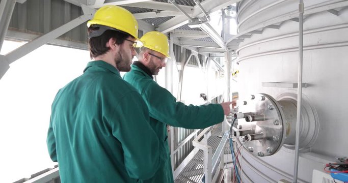 Due Ingegneri aeronautici stanno parlando sul problema in un condotto aerospaziale.