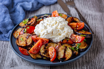 Fried Eggplant with Tomato and Italian stracciatella cheese. Salad on the plate