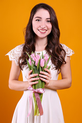 Beautiful female holding bouquet of springtime flowers for international women's day holiday.