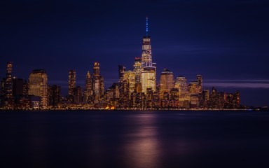 Naklejka premium new york city skyline night sunset cityscape skyscraper buildings lights lighting sea architecture river manhattan downtown new-york traveling panorama twilight sky
