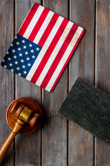 Law and justice in USA concept. Judge gavel near american flag on dark wooden background top-down