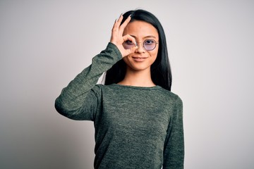 Young beautiful chinese woman wearing glasses and t-shirt over isolated white background doing ok gesture with hand smiling, eye looking through fingers with happy face.