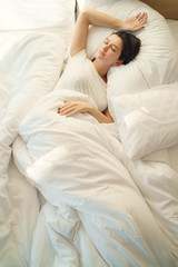 Young beautiful alone woman sleeping on bed in bedroom