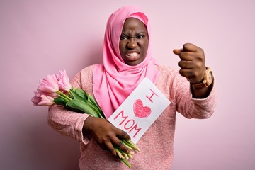 Plus size african american woman wearing hijab holding message and tulips on mothers day annoyed and frustrated shouting with anger, crazy and yelling with raised hand, anger concept