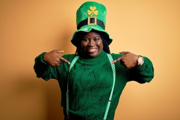 Plus size african american woman with braids wearing green hat with clover on st patricks day...