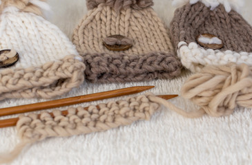 knitting themed background in neutral beige colours with pompom hats 