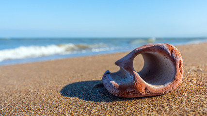 Bizarre stone with hole on the seashore