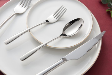 The silver tableware used for the wedding is on the red background