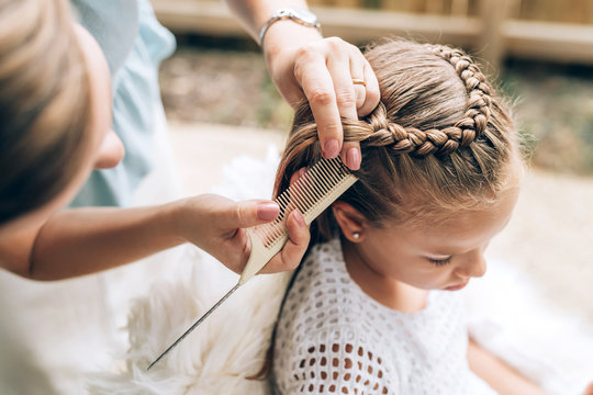 Mother Does Hair Braid To Her Daughter, Close Up Photo.