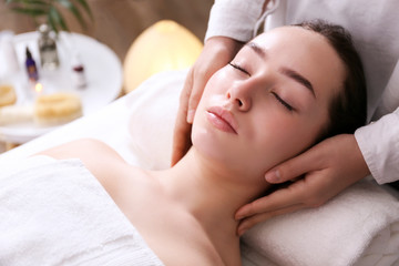 Portrait young beautiful woman lying on the massage table in spa wellness salon. Beauty and health procedures for women concept. Close up, copy space, background.
