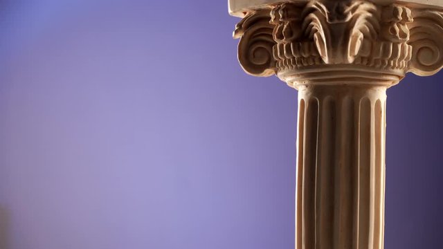 Single ancient column rotating slowly on blue background