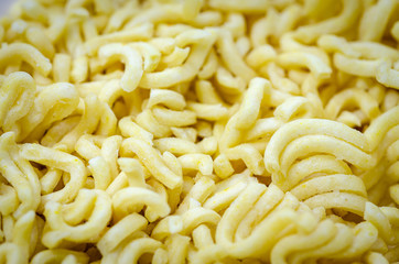Closeup of instant noodles taken out of the packet, ready to be cooked. Background.