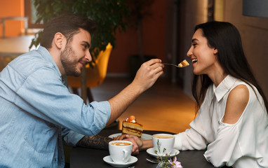 Lovers Feeding Each Other Having Date In Coffee Shop