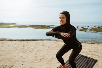 squats, sport muslim woman with scarf squatting outdoor